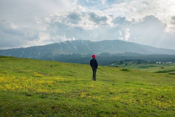 istock Man relaxing on top of mountain in cloudy day. 1439774846