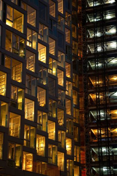istock Vertical shot of an office building windows illuminated at night 1439774867