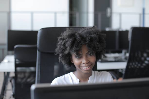 istock Successful African-American female sitting in front of a computer working in a modern startup office 1439774913
