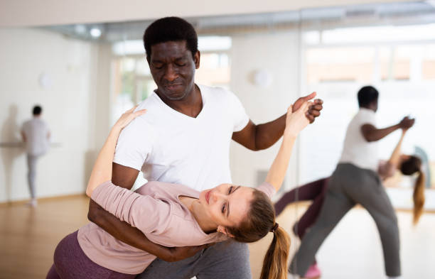 Man and woman practicing salsa moves in dancing room