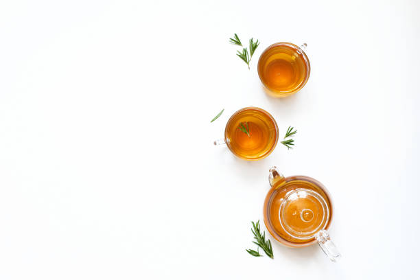 Herbal tea with rosemary in a glass teapot on a white background. Top view