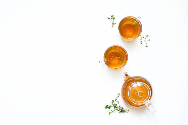 istock Herbal tea with thyme in a glass teapot on a white background. Top view 1439775781
