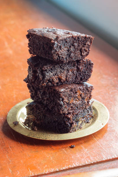 Stack of Baked Chocolate Brownies on a Plate on a Wooden Table with Copy Space