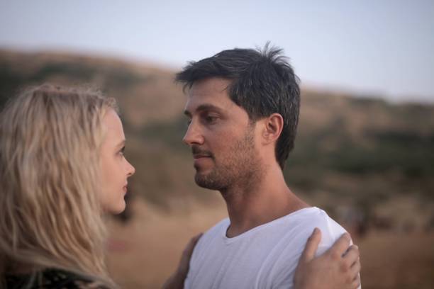istock Young couple looking at each other with affection under the sunlight at daytime 1439777521