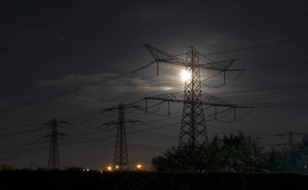 istock Electricity pylons at night in moonlight 1439777528