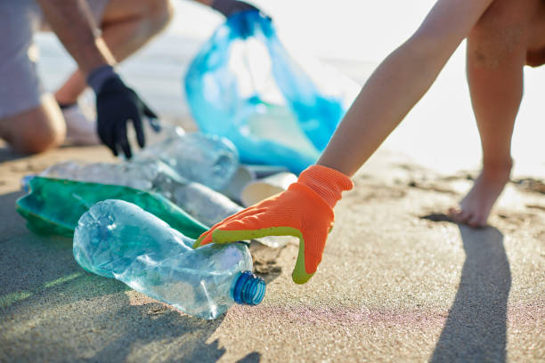 istock Boy wearing glove picking up plastic bottle 1439778689