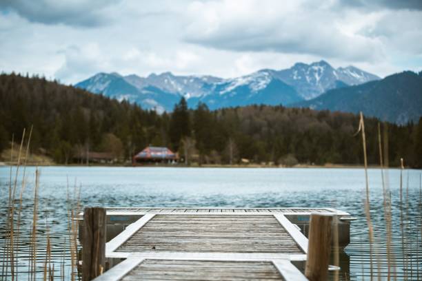 a pier leads out to the lautersee near mittenwald in the bavarian alps - lautersee lake imagens e fotografias de stock