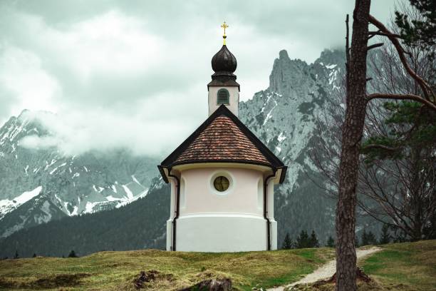 バイエルンアルプスの山々にある美しい小さなカトリック教会 - lautersee lake ストックフォトと画像