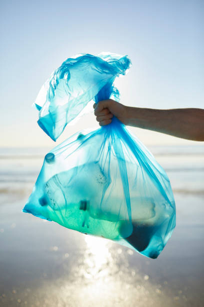 mano dell'uomo che tiene la spazzatura nel sacchetto di plastica - disposable cup plastic recycling cup foto e immagini stock