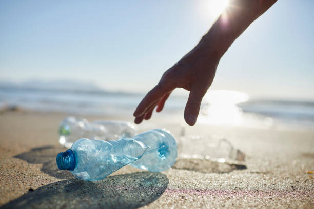 istock Hand of man picking up abandoned plastic bottles 1439779944