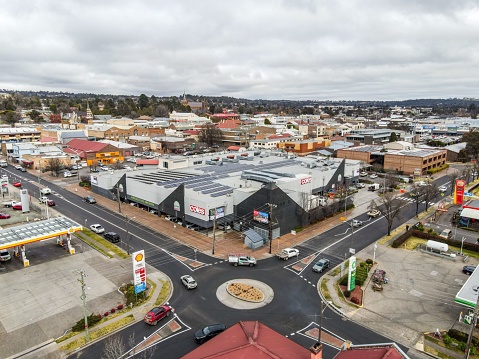 Armidale, Australia – July 13, 2022: An aerial view of Armidale city with traffic on roads, old buildings, and a shopping center