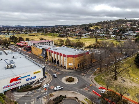 Armidale, Australia – July 13, 2022: An aerial view of Armidale city with traffic on roundabout and shopping centers on a cloudy day