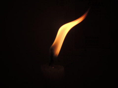 The small yellow and orange flame in the dark