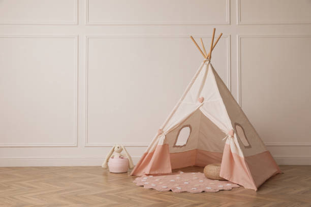 istock Cute child room interior with play tent near white wall, space for text 1439780779
