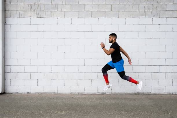 istock Young man running and working out near the white wall 1439781349