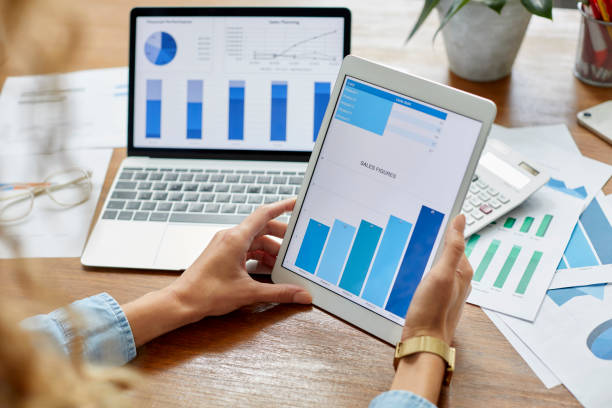istock Businesswoman comparing sales figures on tablet PC 1439782288