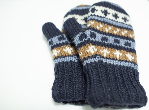 A pair of warm winter gloves on a white background