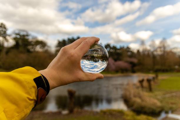 istock Selective focus shot of a human hand holding a glass sphere 1439783045