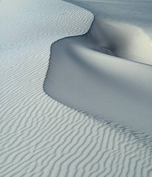 istock Vertical shot of  wavy white sand dune on a daylight 1439783335