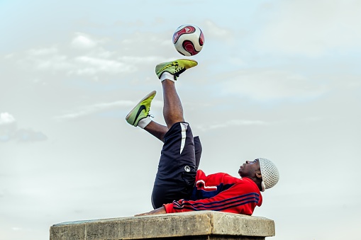 Paris, France – July 13, 2019: A series of images showing a young man performing a show with his football in front of the Sacre Coeur Church in Montmartre, Paris, France.