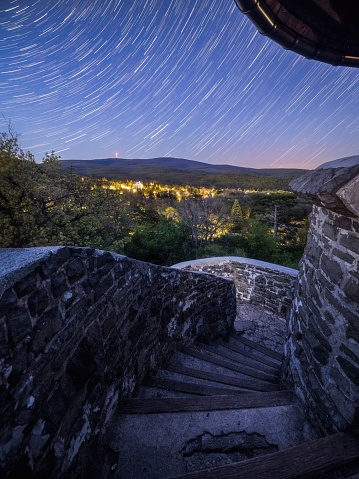 A vertical shot from the Kozmary lookout tower of a meteor shower in the sunset sky