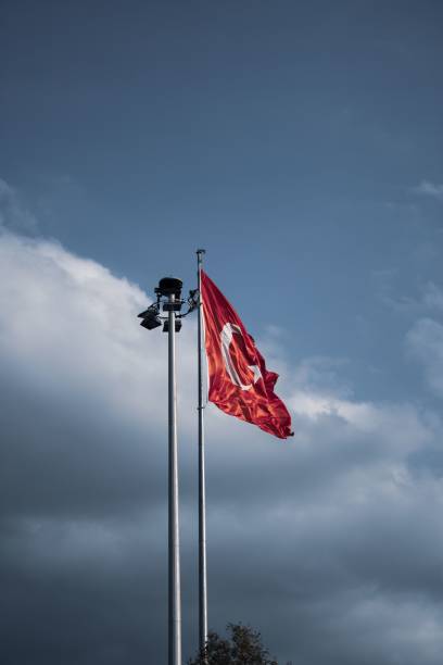 istock Turkey flag on the pole with cloudy sky background 1439786674