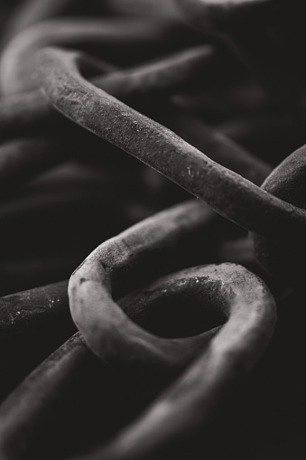 A grayscale shot of old rusty chains