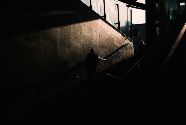 istock Dark underground area with two people walking down the stairs 1439787460