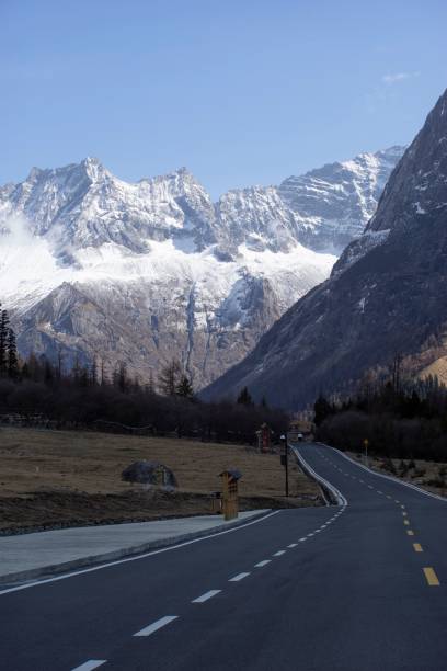 istock Vertical view of an empty road surrounded by snowy mountains 1439787685