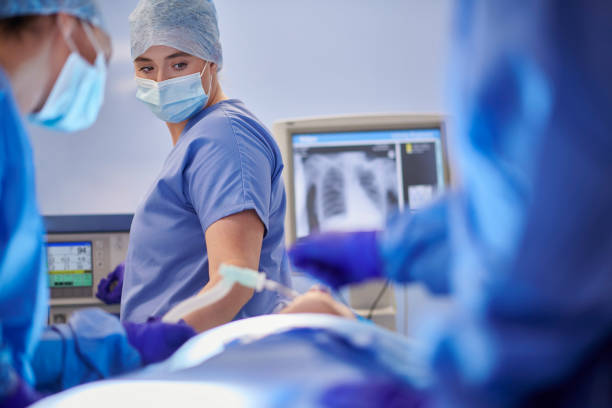 anestesista feminino em cirurgia - surgery emergency room hospital operating room - fotografias e filmes do acervo