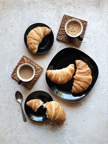 high angle view of coffee served with croissants on stone table