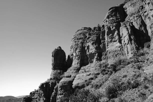 istock Greyscale of rocks covered in grass with blurry hills on the background 1439789841