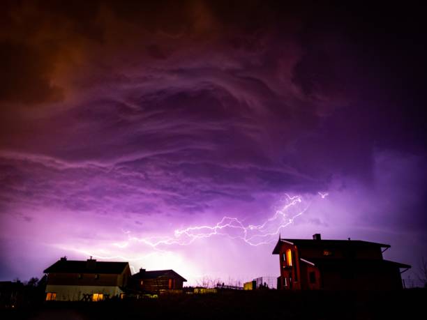 istock Valley with houses on it under a cloudy sky during storm in the night 1439790030