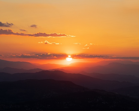 Hermoso paisaje de una cadena montañosa con la impresionante puesta de sol en el fondo photo