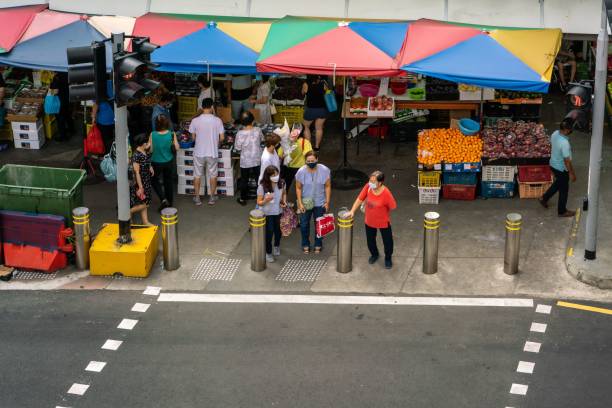 pedoni in attesa al semaforo di bugis street, singapore - editorial asia singapore tourist foto e immagini stock