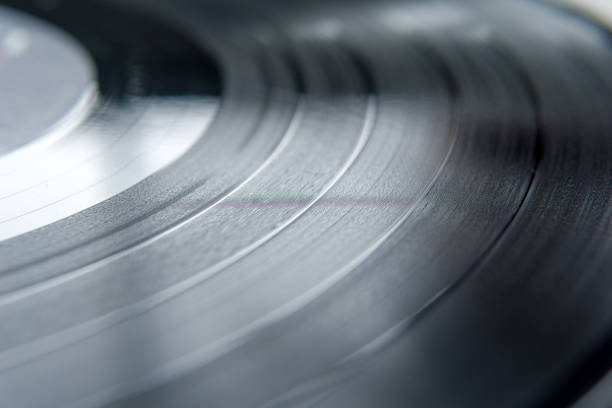 Section of a vinal record A shallow depth of field image of the tracks and grooves of a black vinal record. vinal record stock pictures, royalty-free photos & images
