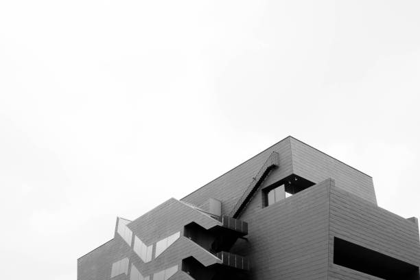 istock Low angle greyscale shot of a concrete modern building isolated on a white background 1439792373