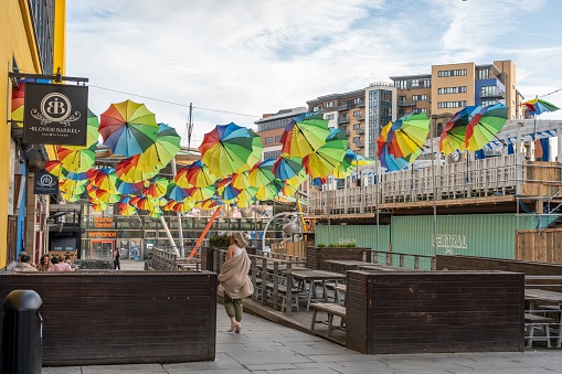 NEWCASTLE UPON TYNE, United Kingdom – July 24, 2022: Brightly coloured umbrellas decorate the bars in Times Square in the city of Newcastle upon Tyne, UK, in celebration of UK Pride.