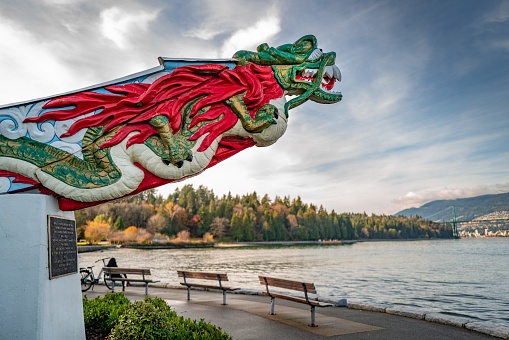 Vancouver, Canada – November 13, 2019: Figurehead of SS Empress of Japan in Stanley Park, Vancouver BC. Background shows someone sitting peacefully under blue skies and high cloud