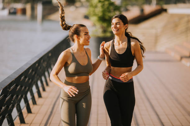 istock Young woman taking running exercise by the river promenade 1439794020