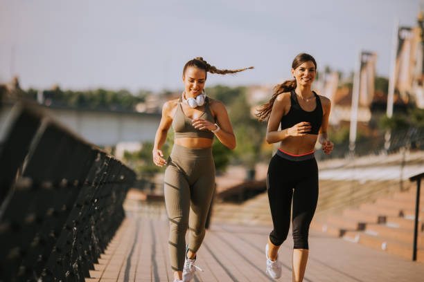 istock Young woman taking running exercise by the river promenade 1439794027