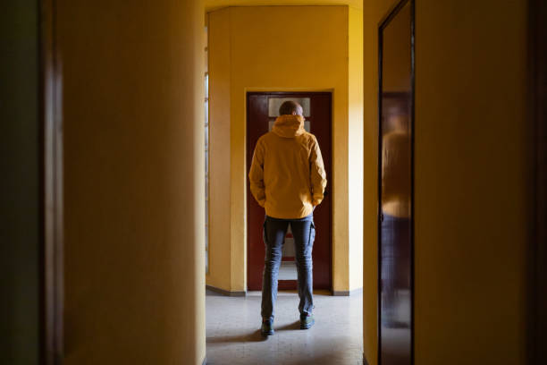 istock Man in yellow jacket in building hallway 1439796197