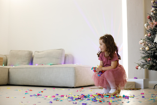 Ecstatic little girl catching falling confetti