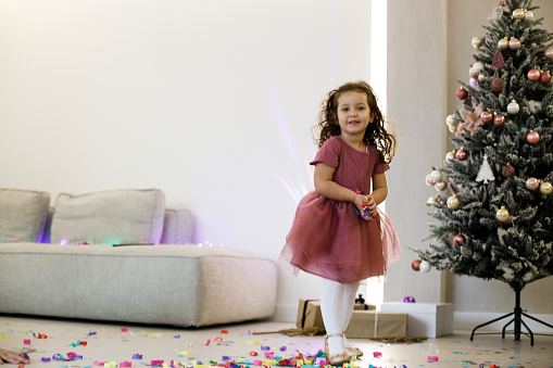 Ecstatic little girl catching falling confetti