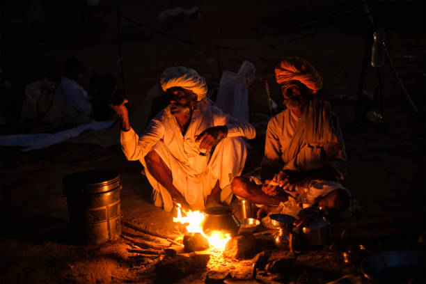 プシュカルラクダフェアプシュカルメラでのインドの男性とラクダ - india campfire desert camel ストックフォトと画像