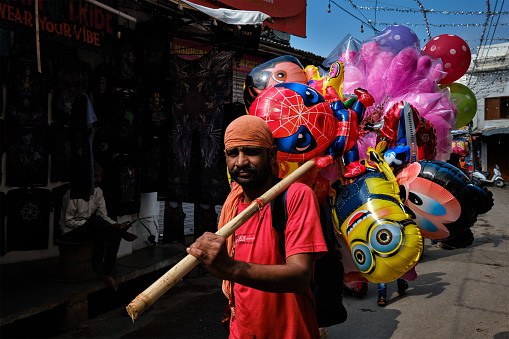 Pushkar, India - November 7, 2019: Man street vendor selling balloons in the street of Pushkar, Rajasthan, India