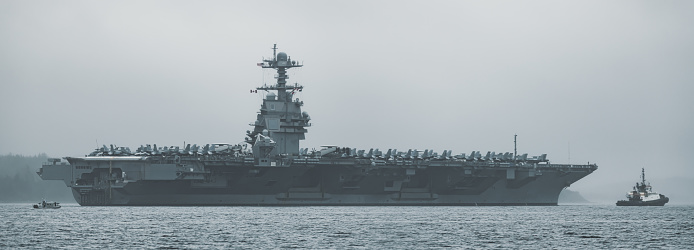 An American aircraft carrier departs a harbour after a weekend in port.