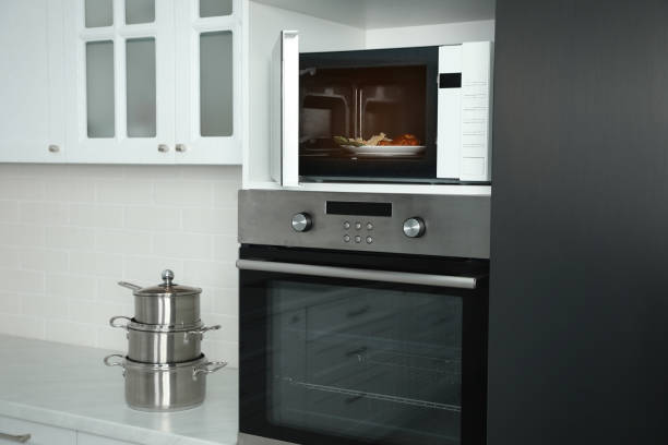 istock Open microwave oven with food on white shelf in kitchen 1439801498