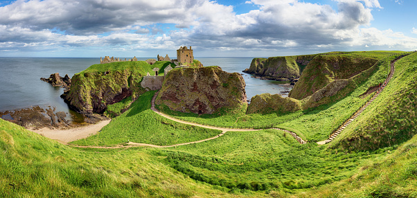 Cliff  in a bay with blue sky and white cloudsnear  in Dunnottar Castle, Scotland - UK