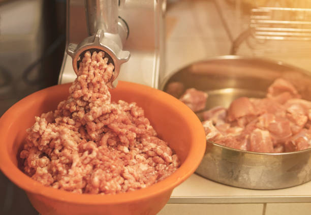 istock Meat grinder mincing fresh raw meat. Selective focus on an automatic electric meat mincer at home. 1439803166